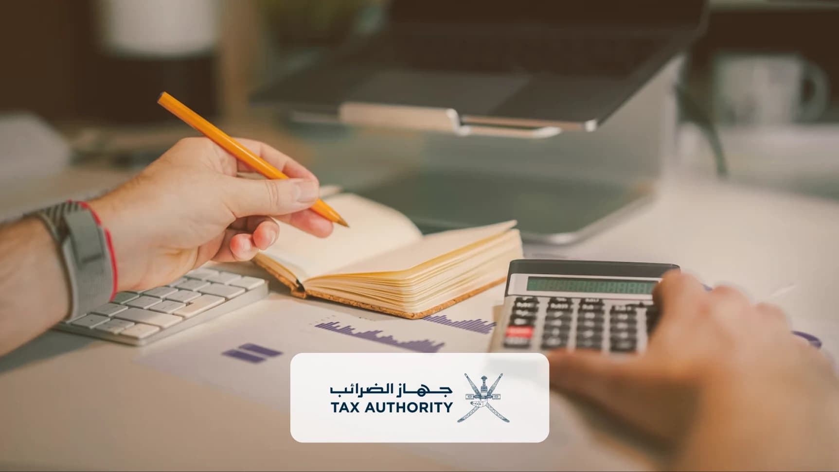 مكتب: يد تمسك قلماً فوق دفتر مفتوح، بجانبه آلة حاسبة ولوحة مفاتيح وتقرير مطبوع، وشعار جهاز الضرائب في المقدمة.